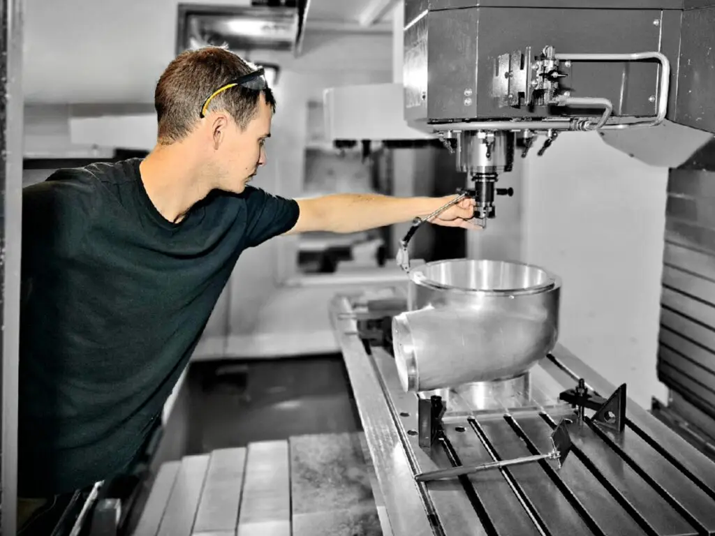 A man operating an industrial machine in a factory.